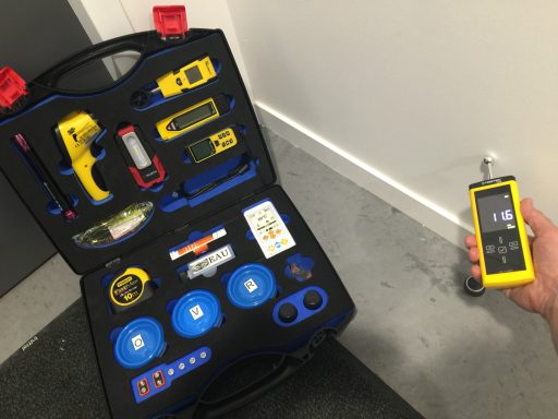 Valise à outils ouverte avec divers instruments de mesure et appareil à main.